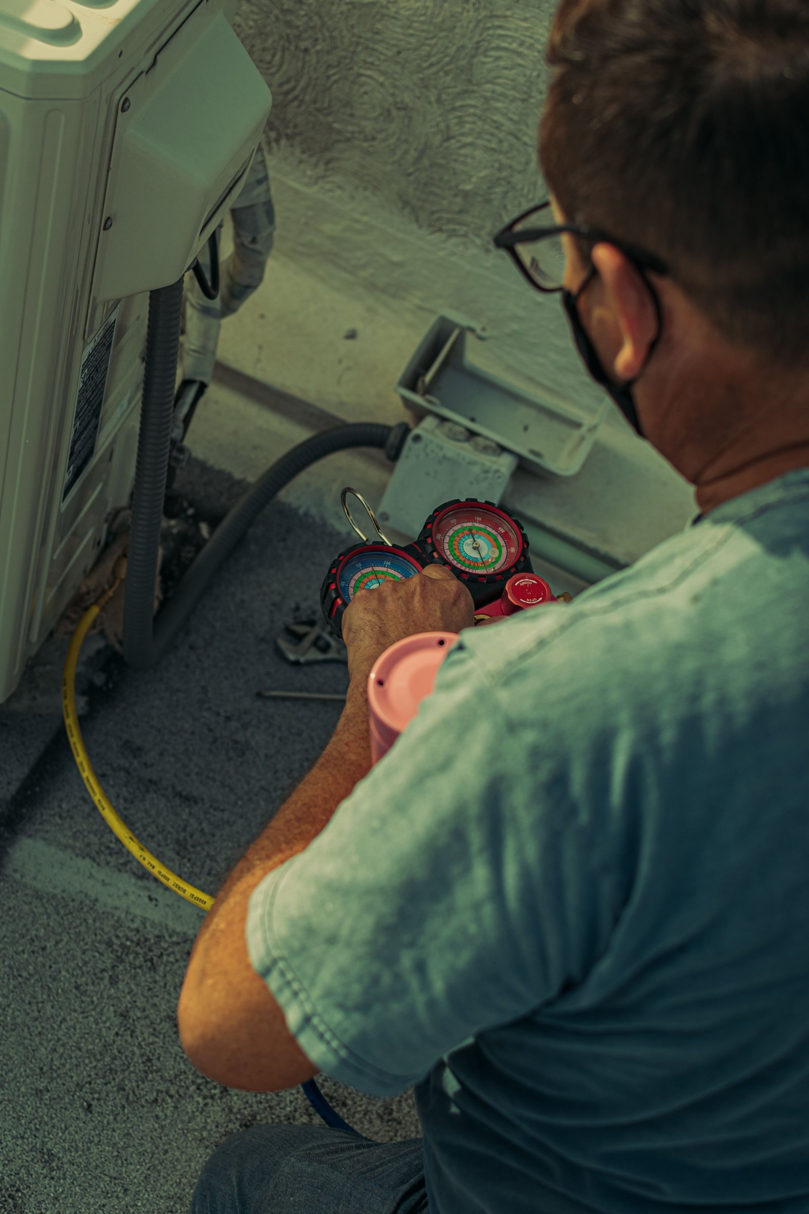 Stock photo of an HVAC technician checking an air conditioning system